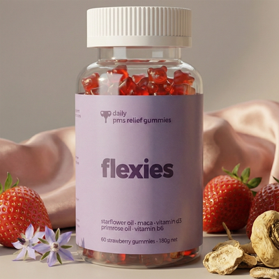 Bottle of Flexies pms relief gummies with strawberries and flowers on a neutral background
